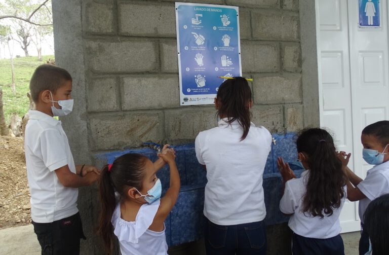 Kinder waschen Hände an von BORDA gebauter Waschanlage mit Hygieneanleitung