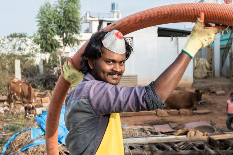 Lächelnder Arbeiter bei Installation von Wasserinfrastruktur für nachhaltige Wasserversorgung
